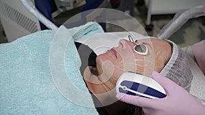 The procedure of laser correction of the oval of the face in a cosmetic clinic.