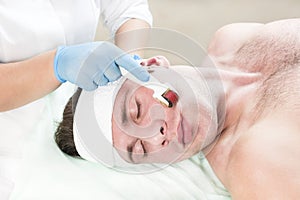 Procedure of medical micro needle therapy with a modern medical instrument derma roller. photo