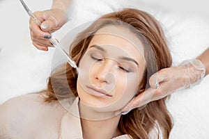 Procedure Non contact cleaning skin of face from blackheads, acne. Doctor performs body are of young woman in clinic