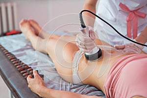 Procedure removing cellulite on female abdomen, cavitation belly massage. Ultrasonic massage for weight loss. Correction