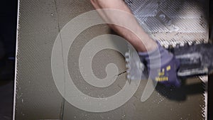 The process of applying tile adhesive to a large porcelain stoneware slab. Residential renovation work