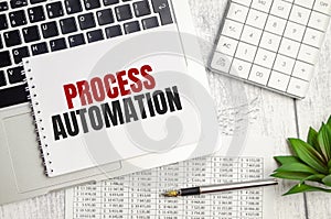 PROCESS AUTOMATION text on notepad and laptop, calculator and pen