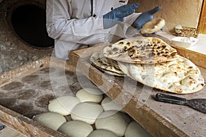 Process of baking bread in a traditional Georgian stove - tone, tandoor. A male cook makes tortillas. The preparation of