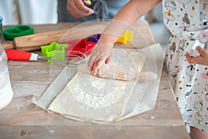 The process of baking from dough. hands roll out the dough and make cookies in the form of asterisks on the dough