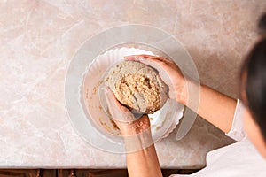 Process of baking health bread at home. closeup woman hands kneading dough from rye flour on marble countertop in bright kitchen