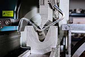 Sheet metal bending on a hydraulic bending machine. Metal part after bending photo