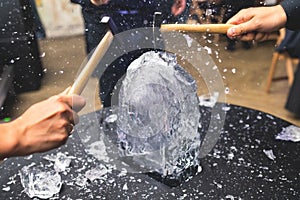 Process of breaking the ice with hammer and ice pick, group of people smashing shattered ice cube, team work success concept,