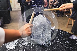 Process of breaking the ice with hammer and ice pick, group of people smashing shattered ice cube, team work success concept,