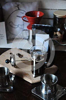 The process of brewing coffee. Pour water from the drip maker into the french press. Pack with white label