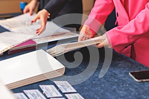 Process of checking in on a conference congress forum event, registration desk table, visitors and attendees receiving a name