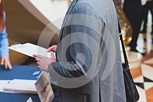 Process of checking in on a conference congress forum event, registration desk table, visitors and attendees receiving a name