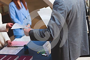 Process of checking in on a conference congress forum event, registration desk table, visitors and attendees receiving a name