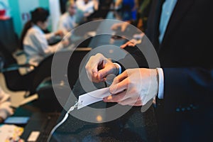 Process of checking in on a conference congress forum event, registration desk table, visitors and attendees receiving a name