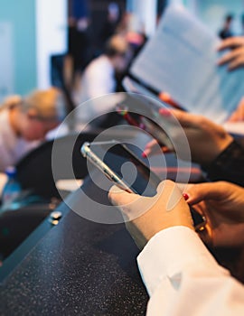 Process of checking in on a conference congress forum event, registration desk table, visitors and attendees receiving a name