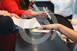 Process of checking in on a conference congress forum event, registration desk table, visitors and attendees receiving a name