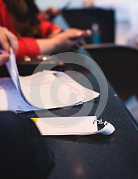 Process of checking in on a conference congress forum event, registration desk table, visitors and attendees receiving a name