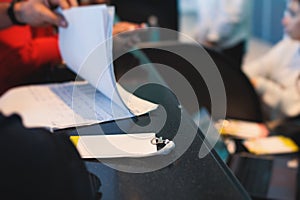 Process of checking in on a conference congress forum event, registration desk table, visitors and attendees receiving a name