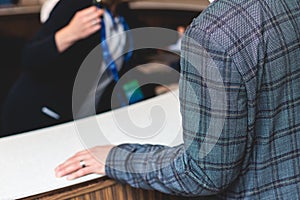 Process of checking in on a conference congress forum event, registration desk table, visitors and attendees receiving a name