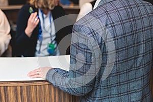 Process of checking in on a conference congress forum event, registration desk table, visitors and attendees receiving a name