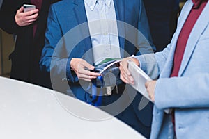 Process of checking in on a conference congress forum event, registration desk table, visitors and attendees receiving a name