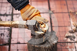 The process of chopping an ax with wooden branches for a fire