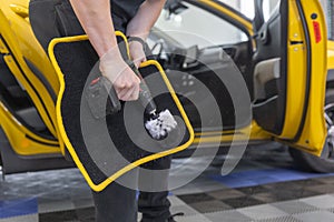 Process of cleaning a car mat by an automatic brush cleaner, car detailing concept