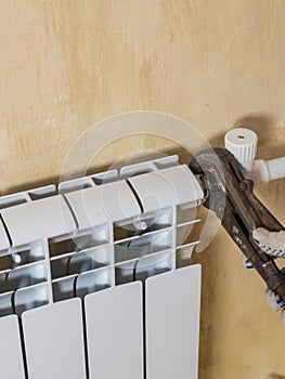 The process of connecting the radiator to the heating system. Accident of the heating system of a private house.