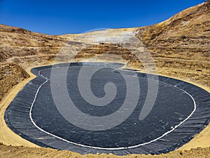 Process of constructing water pools with geosynthetic materials at the bottom of an open-pit mine photo