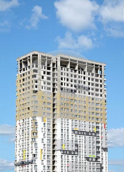 Process of construction high-rise modern apartment building with penthouse over blue sky in sunny day