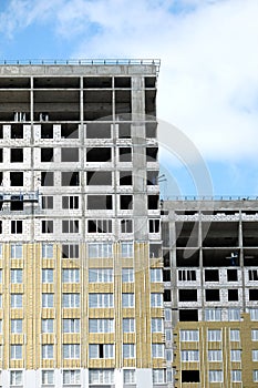 Process of construction high-rise modern apartment building with penthouses on sunny day