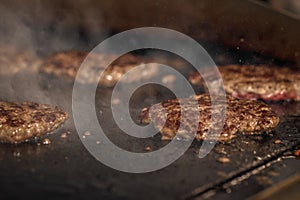 Process of cooking cheeseburgers on the grill. Close up beef meat burgers for hamburger.