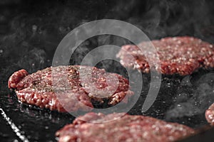 Process of cooking cheeseburgers on the grill. Close up beef meat burgers for hamburger.