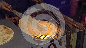 Process of cooking exotic thai pancakes on an open fire on a night market in Thailand. Thai food concept. Asian food