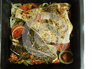 the process of cooking flounder with herbs, onions, tomatoes and white wine