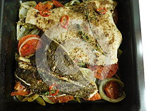the process of cooking flounder with herbs, onions, tomatoes and white wine