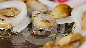 Process of cooking fried champignon mushrooms with onion in olive oil in a frying pan, close up. Stirring fried onion