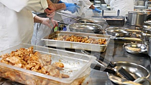 The process of cooking in the kitchen of the restaurant, the chef and his assistants prepare meat, vegetables for the