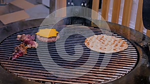 Process of cooking pieces of meat, burgers bums, cutlet and pita on grill