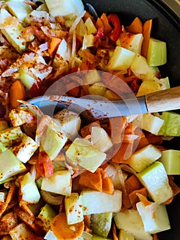 Process of cooking saute at home. Stewed vegetables and silicone spatula with wooden handle in frying pan. Mixed Ingredients