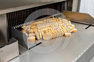 The process of cutting a baguette. Sliced bread on the production line of food and bakery products. One of the stages of the