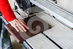 The process of cutting a ceramic step for a staircase using special equipment. Close-up. Unrecognizable person