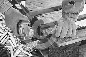 The process of cutting metal using the angle grinder. Grayscale effect