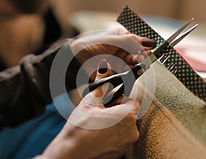 The process of cutting paper with scissors. scissors in female hands close-up
