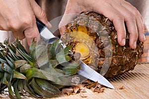 Process of cutting pineapple on a cutting board