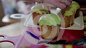 The process of decorating with sweet icing Easter cakes. Close-up of the cook`s hands.