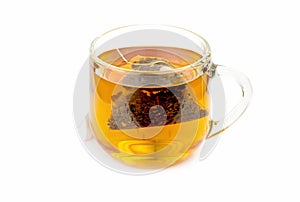 The process of dipping a bag of tea in a glass cup on a white background
