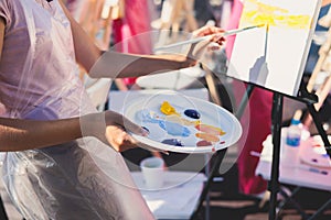 Process of drawing, group class of talented students with painting easels and canvases during lesson of watercolour painting