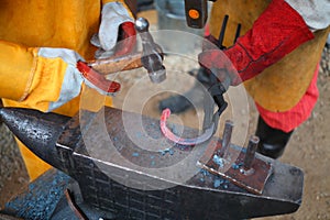 Process of forging iron red-hot horseshoe on anvil photo