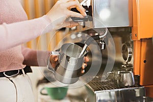 Process of frothing milk with a cappuccino maker in order to prepare latte macchiato drink, barista work