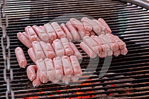 Process of grilling fresh meat sausages on big round grill